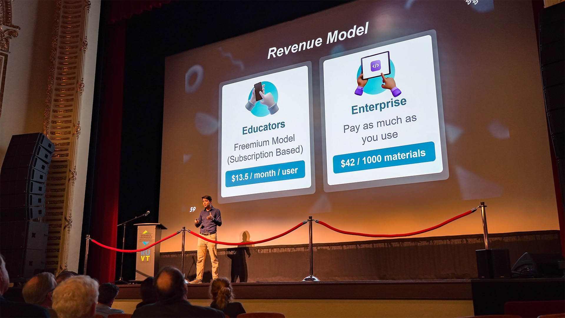 A founder pitching a revenue model slide on stage at a Rutland startup pitch event, backed by CEDRR